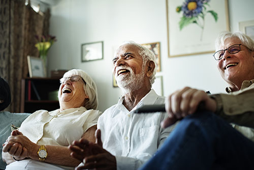 seniors on the couch watching television at Senior Respite Care