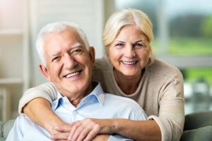 senior woman hugging man enjoying exclusive senior living programs