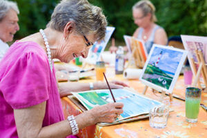 senior woman painting during Senior Living Community Activities in garland tx