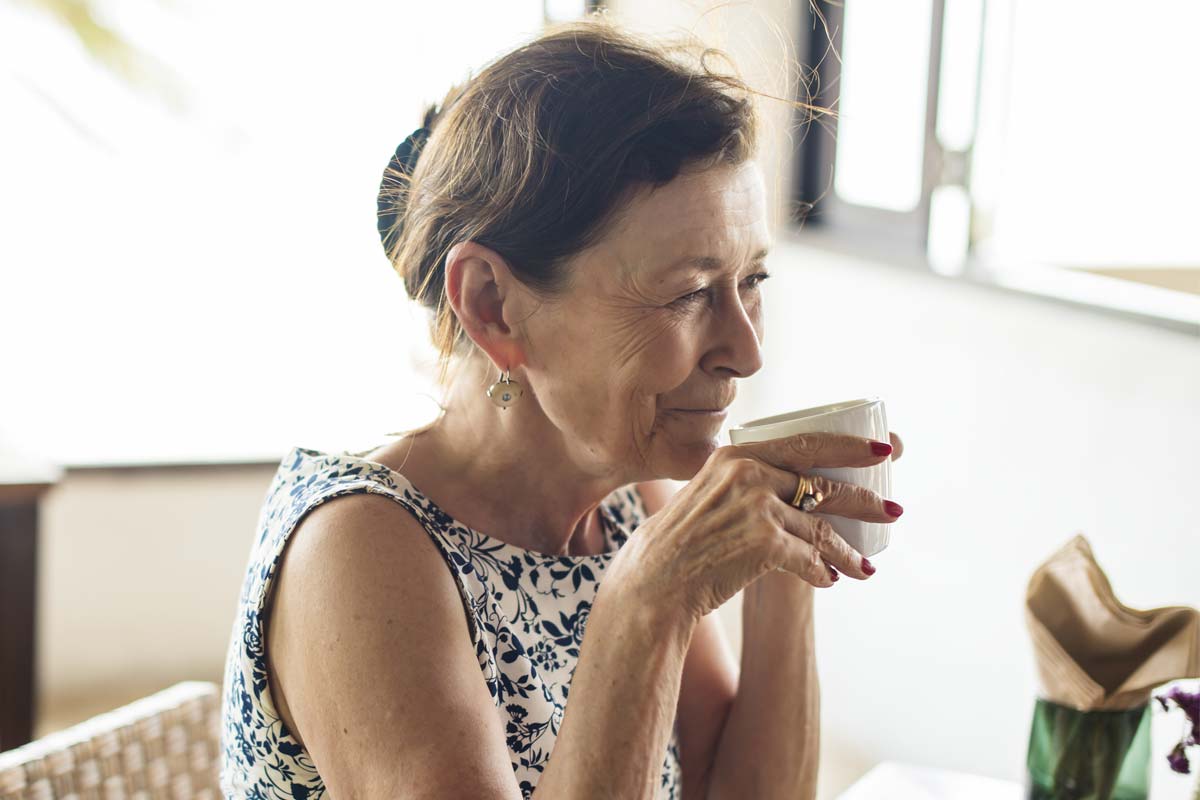 discovery-commons-cypress-point-feature-3-senior-woman-holding-teacup-at-table